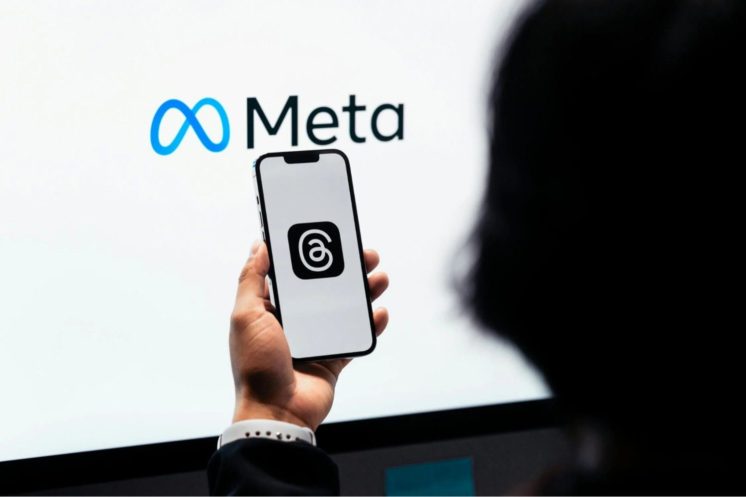 A user launches the Threads app with Meta branding in the background, reflecting the platform’s growing role in Meta’s evolving social media ecosystem.