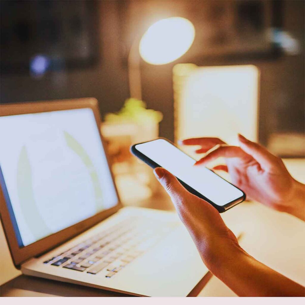 Person using mobile phone and laptop, demonstrating the rise of visual search in AI-driven search technology. 