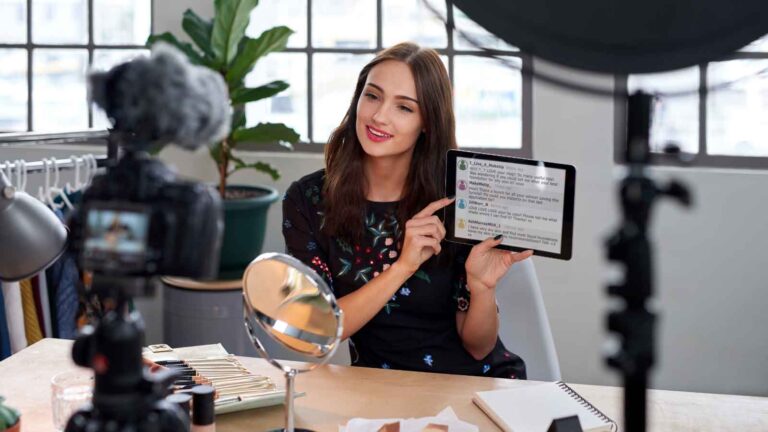 Influencer recording beauty content while showcasing social comments.