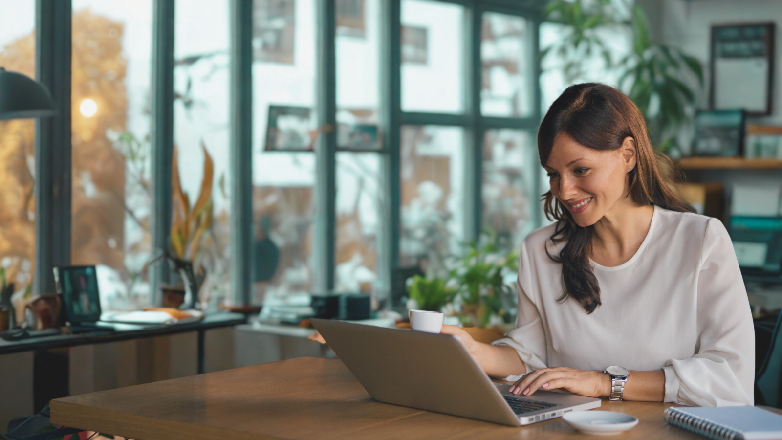 Woman researching citation sites for local business on her laptop in a modern office