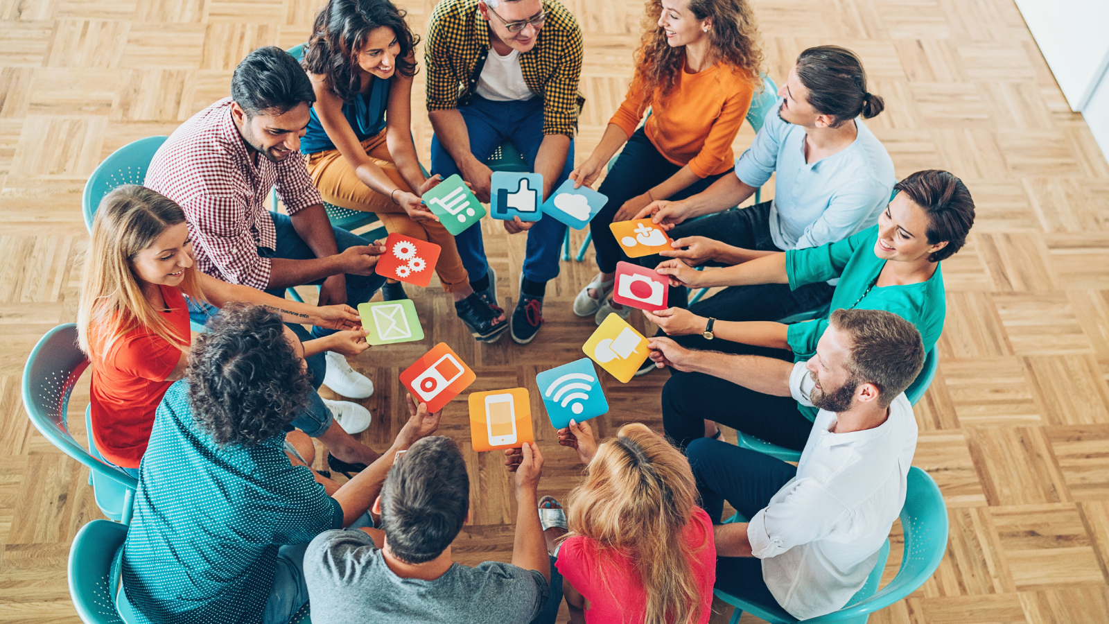 Group of people sitting in a circle holding social media icons