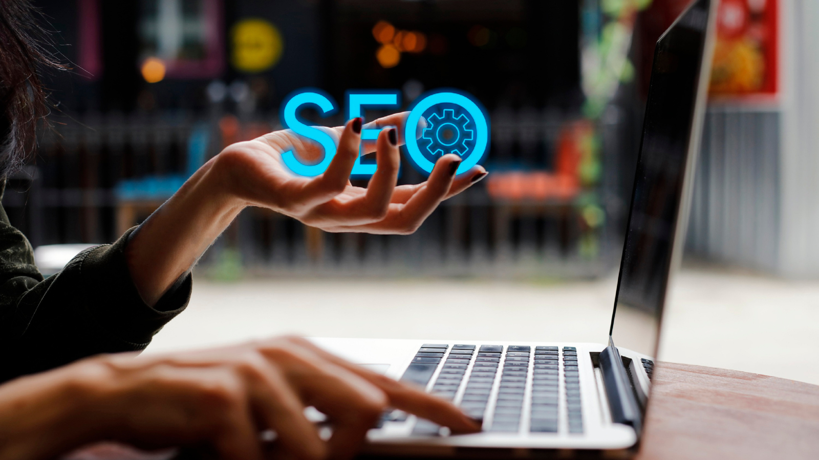 Person using laptop with floating SEO icon above hand