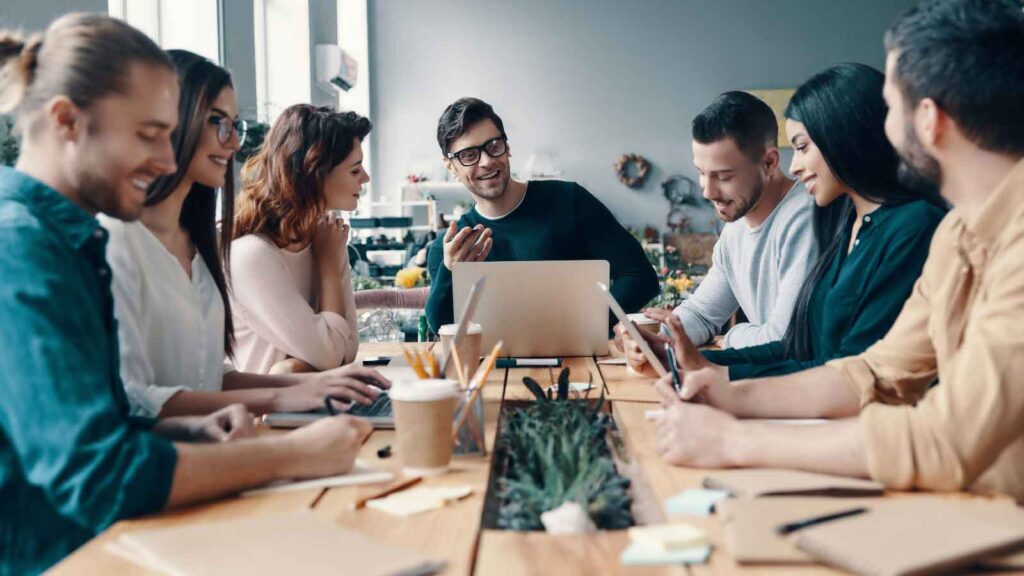 Team meeting around a laptop at a table.