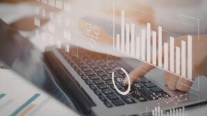 Close-up of hands typing on a laptop with a digital overlay showing bar charts, progress circles, and data folders illustrating local SEO trust signals and community partnership metrics.