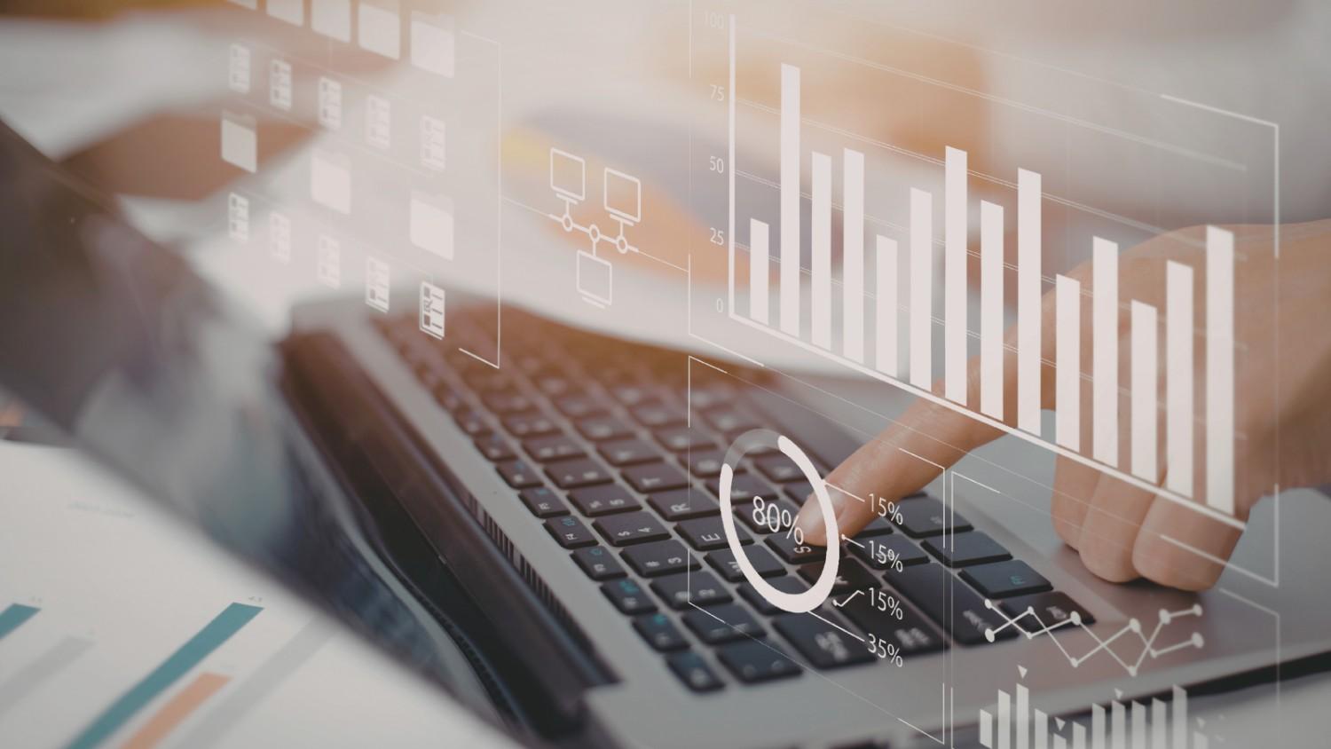 Close-up of hands typing on a laptop with a digital overlay showing bar charts, progress circles, and data folders illustrating local SEO trust signals and community partnership metrics.