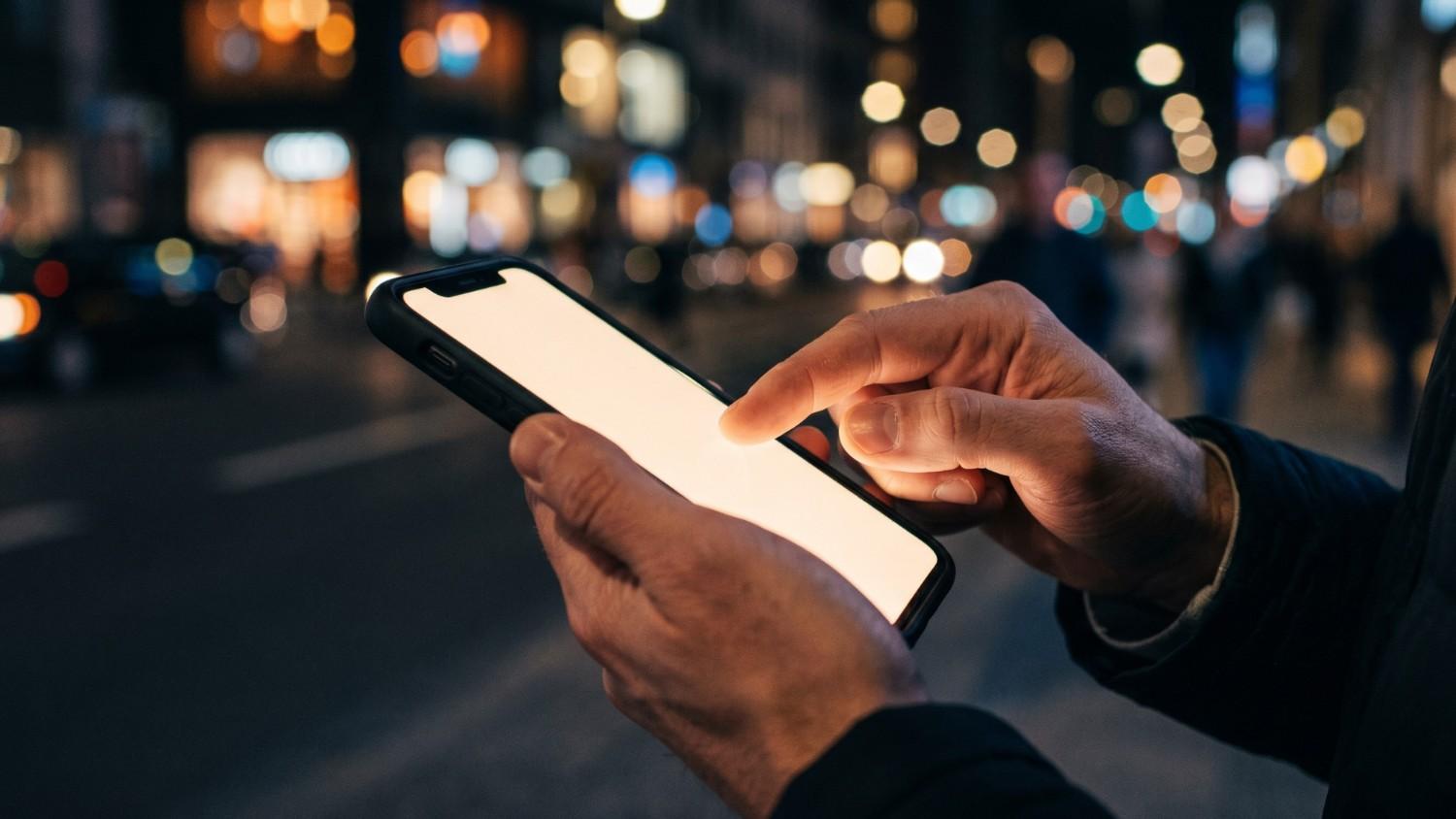 A person tapping a smartphone screen.