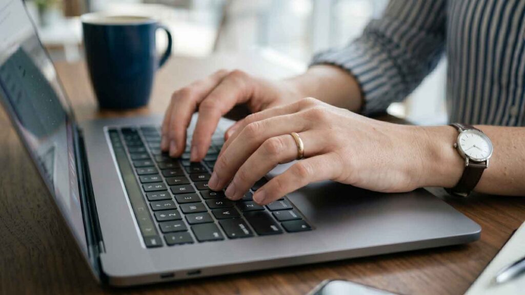 A professional working on a laptop with technical SEO-related tasks.